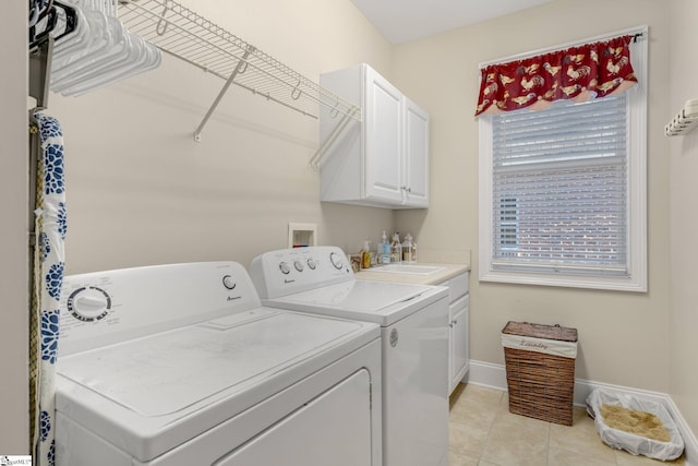 clothes washing area featuring cabinets, light tile patterned floors, and washer and dryer