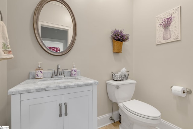 bathroom featuring tile patterned flooring, vanity, and toilet