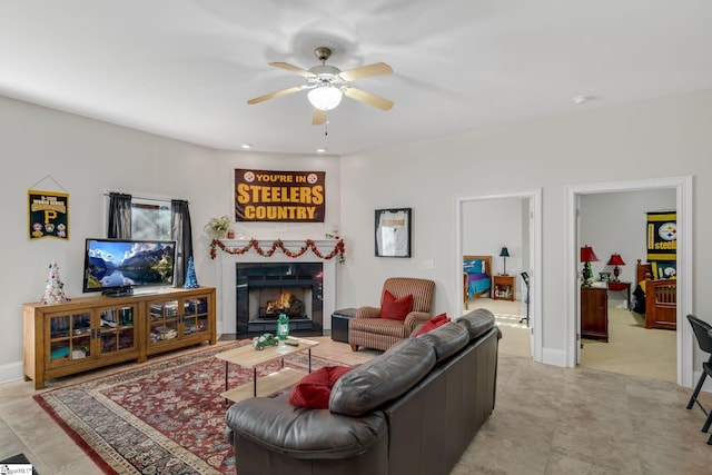 living room with ceiling fan and a tiled fireplace