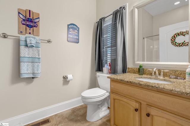 bathroom with tile patterned flooring, vanity, toilet, and a shower