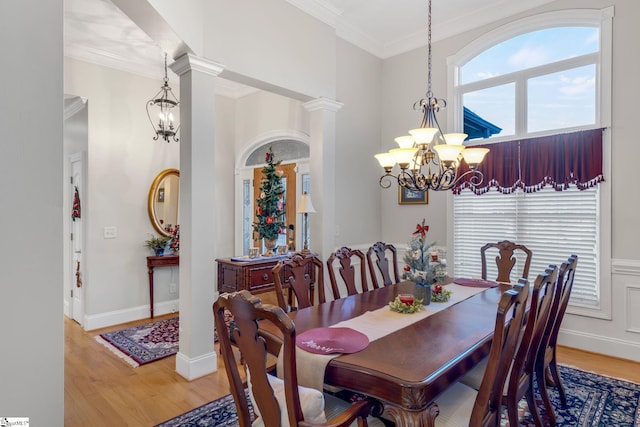 dining room with hardwood / wood-style floors, ornamental molding, and decorative columns