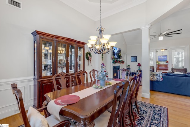 dining area featuring ceiling fan with notable chandelier, crown molding, high vaulted ceiling, and light hardwood / wood-style flooring