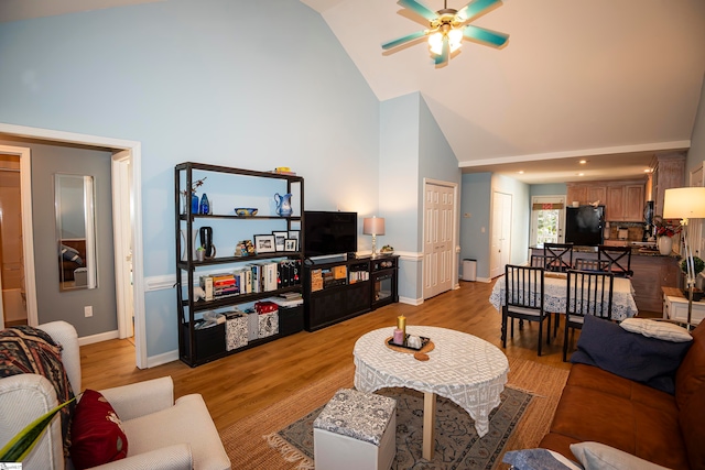 living room with ceiling fan, light wood-type flooring, and high vaulted ceiling