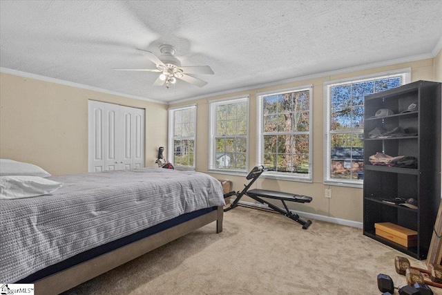 bedroom featuring light carpet, ornamental molding, a textured ceiling, ceiling fan, and a closet