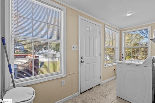 doorway to outside featuring crown molding, light tile patterned flooring, and washer / dryer