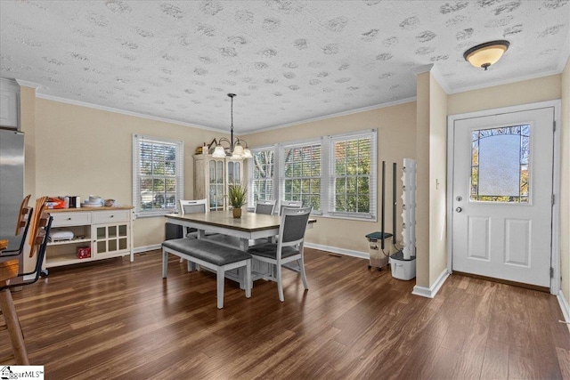 dining room with dark hardwood / wood-style flooring, a chandelier, a textured ceiling, and ornamental molding