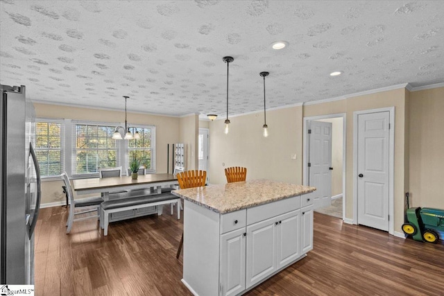 kitchen featuring a center island, dark wood-type flooring, hanging light fixtures, white cabinetry, and stainless steel refrigerator