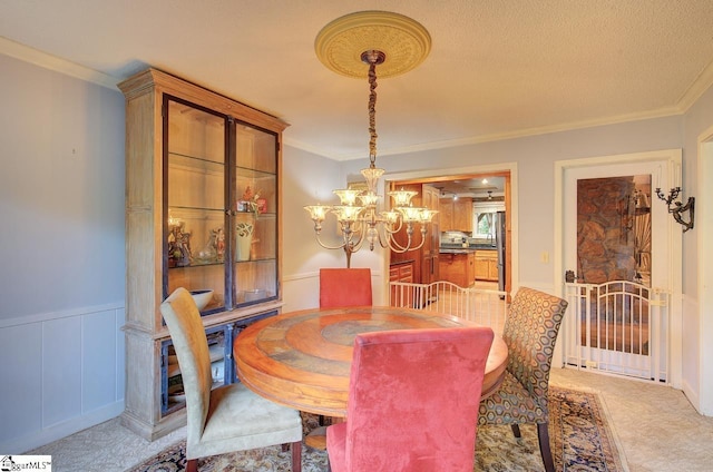 dining space featuring crown molding, carpet floors, and a notable chandelier