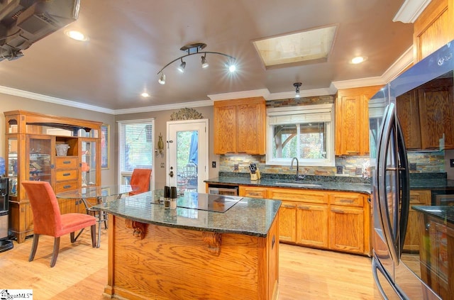 kitchen with a center island, light hardwood / wood-style flooring, a healthy amount of sunlight, and sink