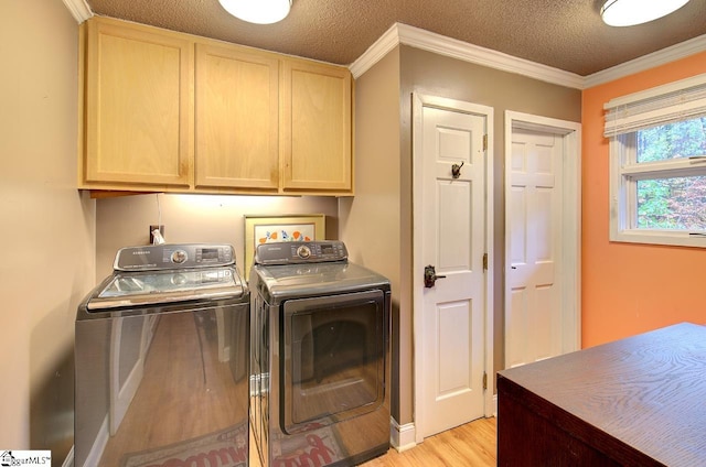 washroom with washing machine and dryer, crown molding, cabinets, and a textured ceiling