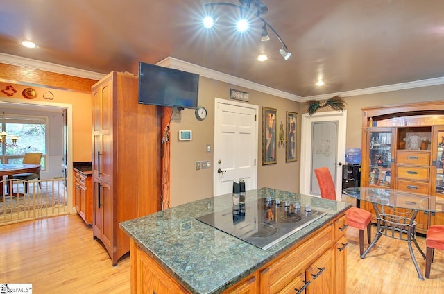 kitchen featuring crown molding, black electric stovetop, a kitchen island, and light hardwood / wood-style flooring