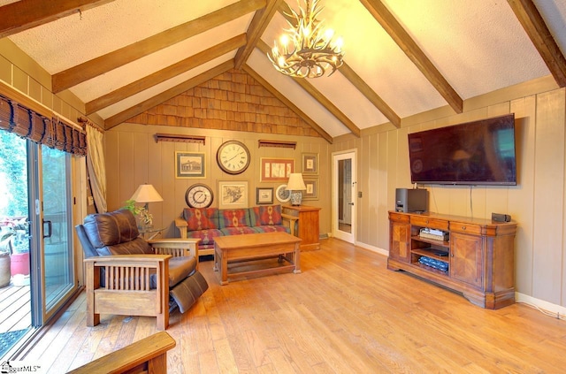 living room with a textured ceiling, wooden walls, light hardwood / wood-style flooring, a chandelier, and vaulted ceiling with beams