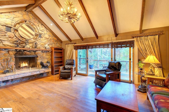 living room with high vaulted ceiling, an inviting chandelier, beamed ceiling, a fireplace, and hardwood / wood-style floors