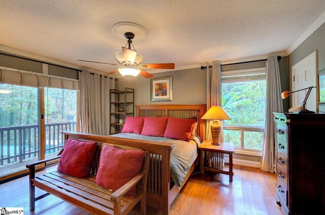 bedroom featuring access to exterior, ornamental molding, a textured ceiling, ceiling fan, and light hardwood / wood-style flooring