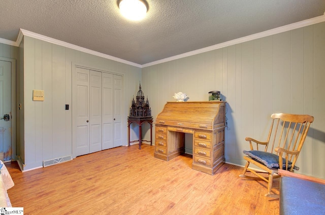 office area featuring light hardwood / wood-style floors, crown molding, and wooden walls