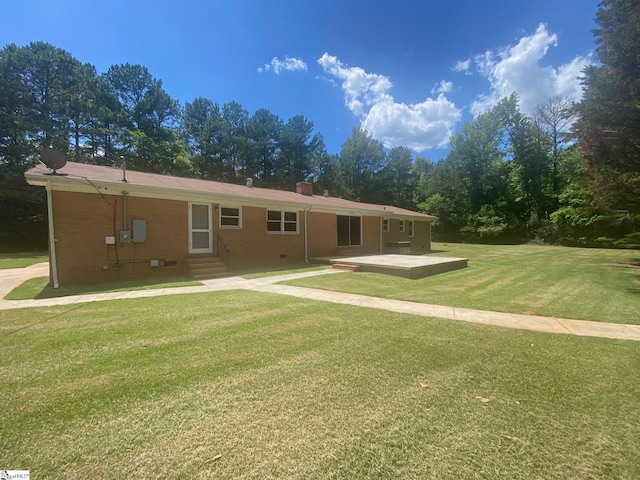 rear view of house with a patio and a lawn