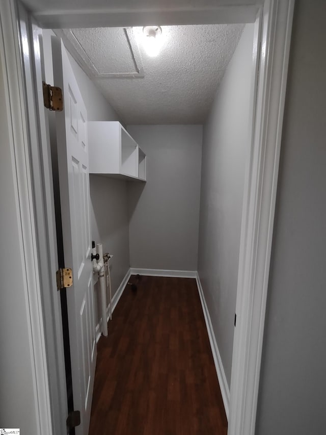 clothes washing area featuring dark hardwood / wood-style flooring and a textured ceiling