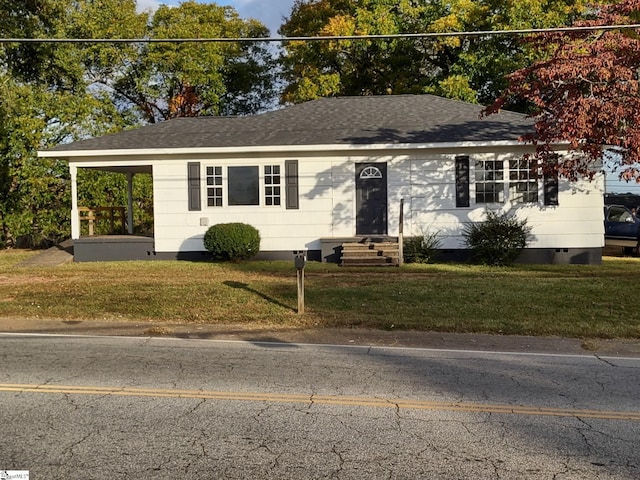 ranch-style house featuring a front yard and a carport