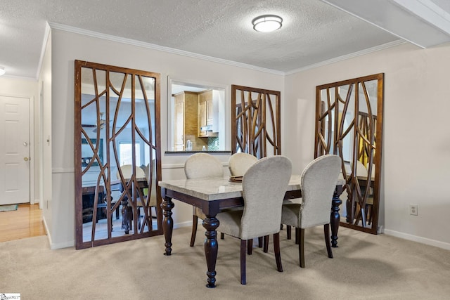 carpeted dining space with ornamental molding and a textured ceiling