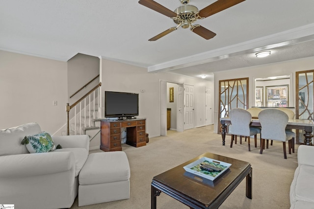 living room with ceiling fan, beamed ceiling, light colored carpet, and a textured ceiling