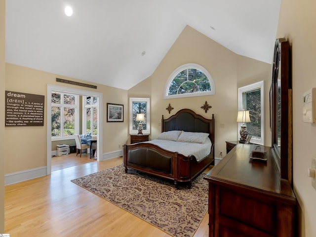 bedroom featuring light hardwood / wood-style floors and high vaulted ceiling