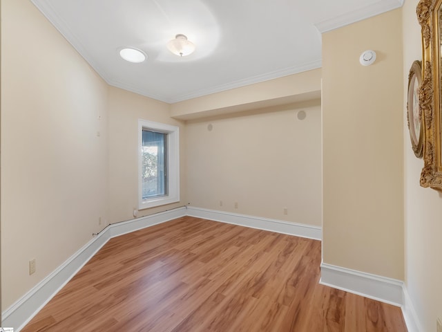 empty room featuring wood-type flooring and crown molding