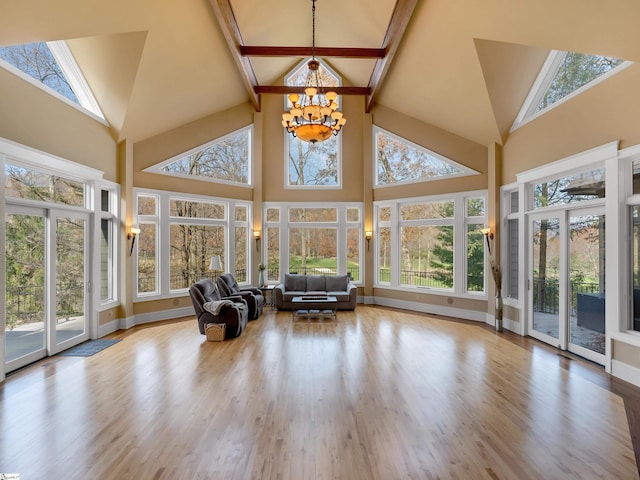 unfurnished sunroom featuring vaulted ceiling with beams and a chandelier