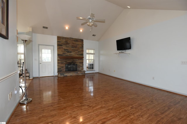 unfurnished living room featuring a stone fireplace, ceiling fan, hardwood / wood-style floors, and high vaulted ceiling