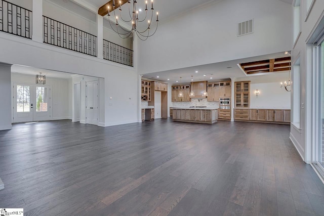 unfurnished living room with beamed ceiling, a towering ceiling, and dark hardwood / wood-style floors