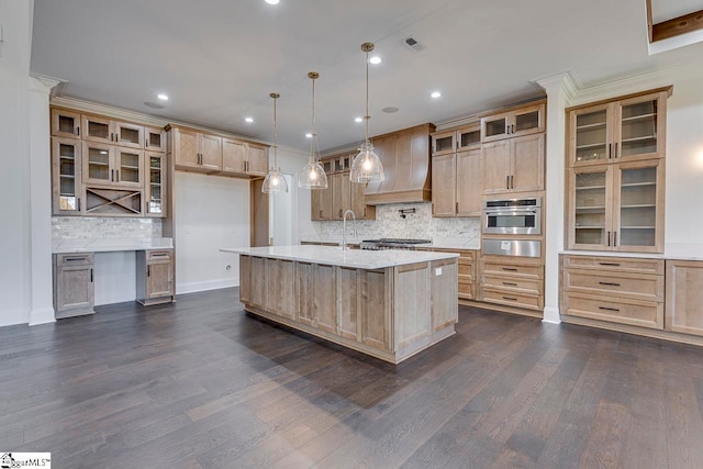 kitchen with a center island with sink, custom exhaust hood, dark wood-type flooring, and stainless steel oven