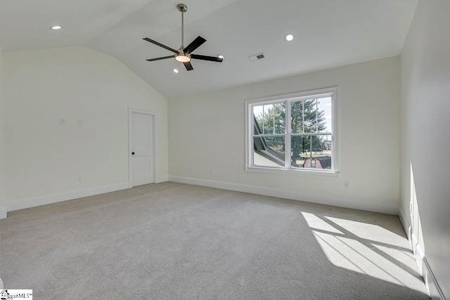 carpeted spare room featuring ceiling fan and vaulted ceiling