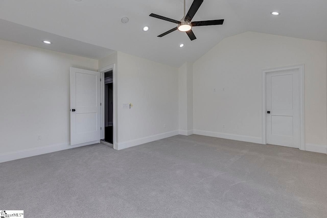 empty room featuring ceiling fan, light colored carpet, and lofted ceiling