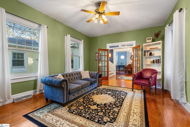 living room with ceiling fan, french doors, and wood-type flooring