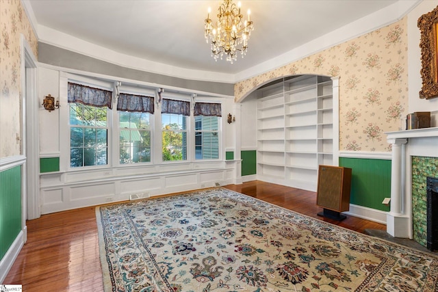 living area featuring a tile fireplace, dark hardwood / wood-style flooring, a chandelier, and built in features