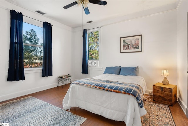 bedroom featuring ceiling fan, dark wood-type flooring, and ornamental molding