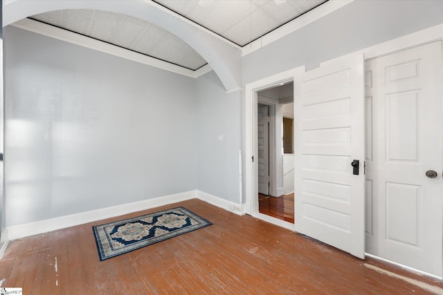 empty room featuring hardwood / wood-style flooring and ornamental molding