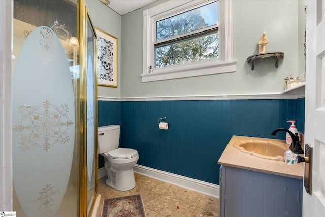 bathroom with vanity, toilet, and a shower with shower door