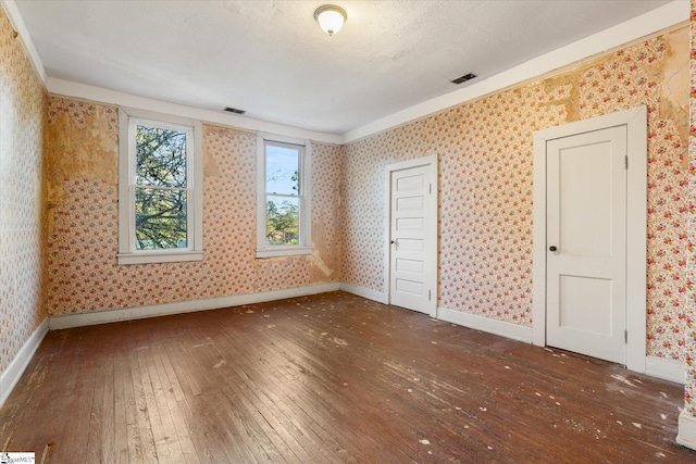 unfurnished bedroom featuring a textured ceiling and dark hardwood / wood-style floors