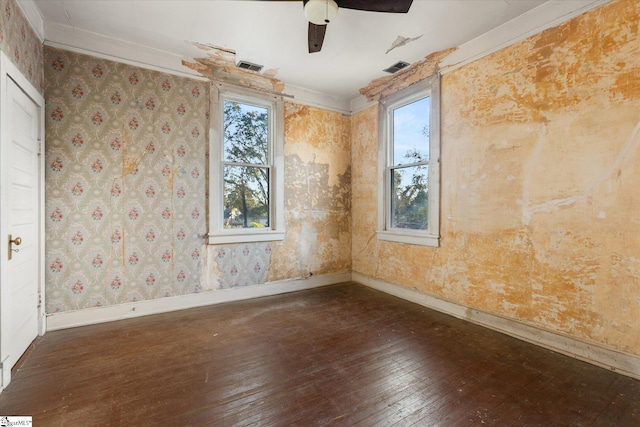 unfurnished room with plenty of natural light, ceiling fan, ornamental molding, and dark wood-type flooring