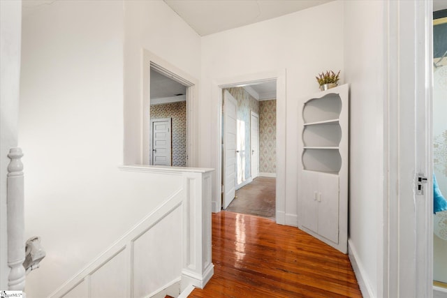 hallway with hardwood / wood-style floors and crown molding