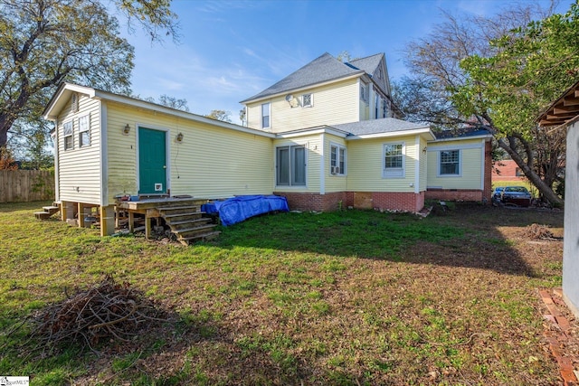 rear view of property featuring a lawn