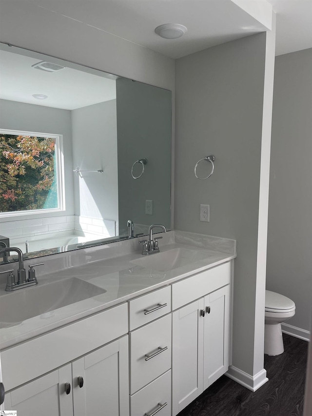 bathroom with toilet, vanity, and hardwood / wood-style flooring