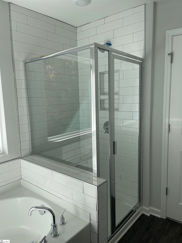 bathroom featuring hardwood / wood-style floors and separate shower and tub