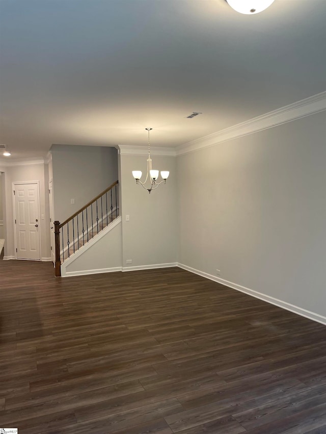 spare room with a chandelier, dark hardwood / wood-style floors, and crown molding