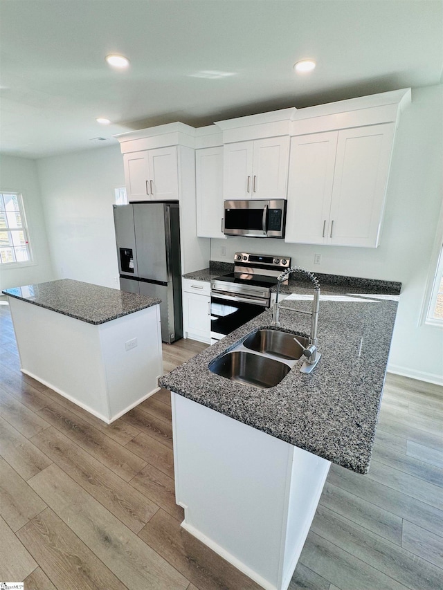 kitchen featuring a center island, stainless steel appliances, and light hardwood / wood-style flooring