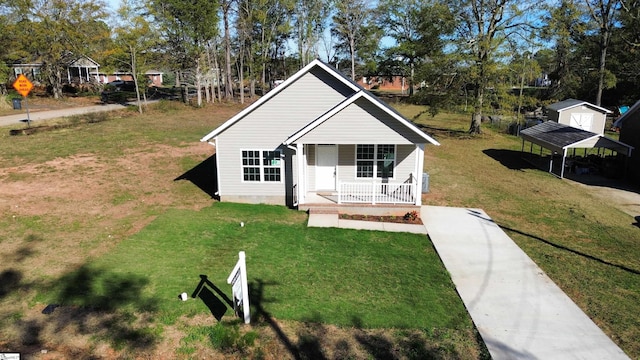 bungalow-style house with covered porch, a carport, and a front lawn