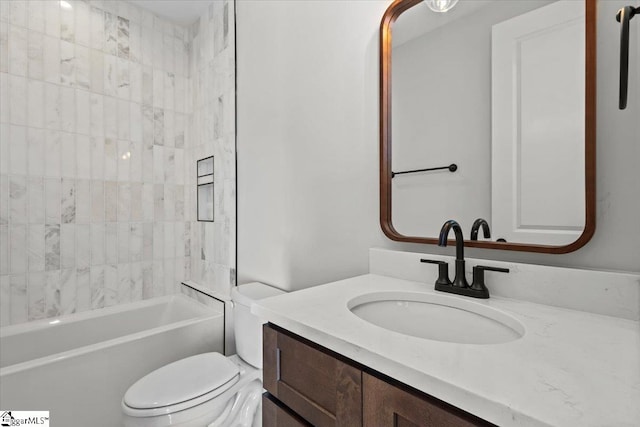 full bathroom featuring vanity, tiled shower / bath combo, and toilet