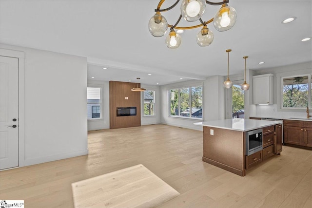 kitchen featuring an inviting chandelier, a kitchen island, and light wood-type flooring