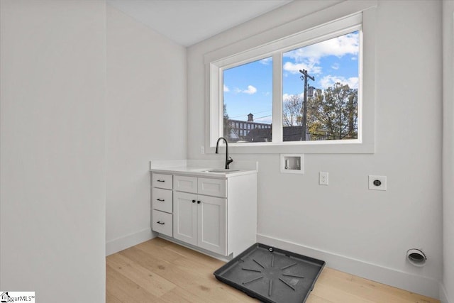 clothes washing area featuring hookup for a washing machine, hookup for an electric dryer, light hardwood / wood-style flooring, and sink