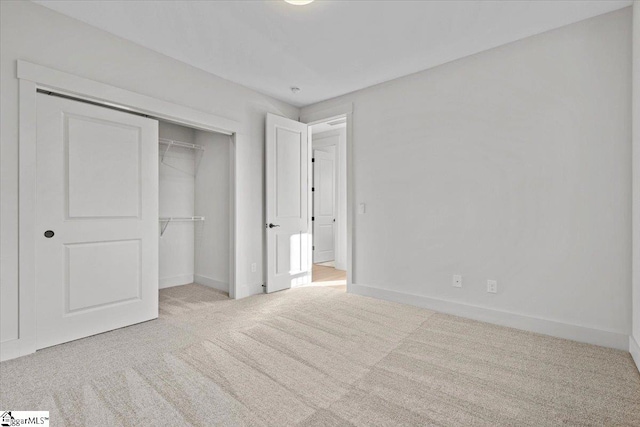 unfurnished bedroom with light carpet and a closet